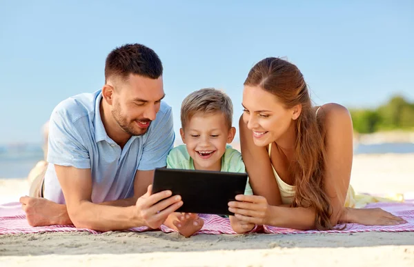 Szczęśliwa rodzina z tabletem na letniej plaży — Zdjęcie stockowe