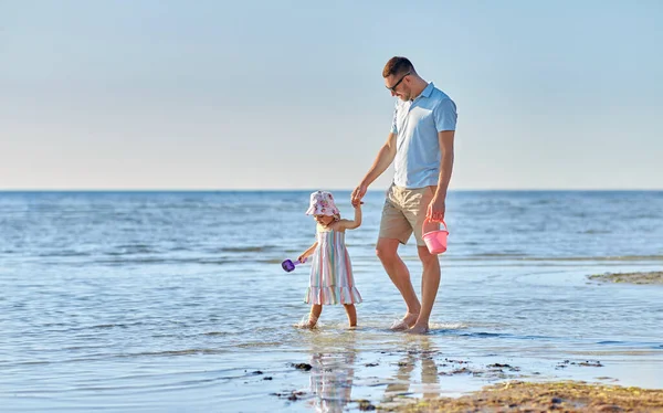 Heureux père marche avec petite fille sur la plage — Photo