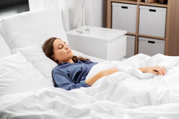 Mujer joven durmiendo en la cama en casa —  Fotos de Stock