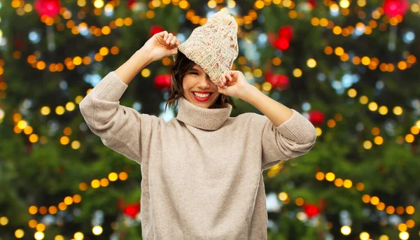 Mulher feliz em chapéu de malha sobre a árvore de Natal — Fotografia de Stock