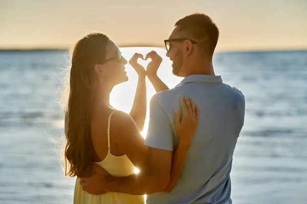 Ευτυχισμένο ζευγάρι δείχνει καρδιά χέρι στην παραλία του καλοκαιριού — Φωτογραφία Αρχείου