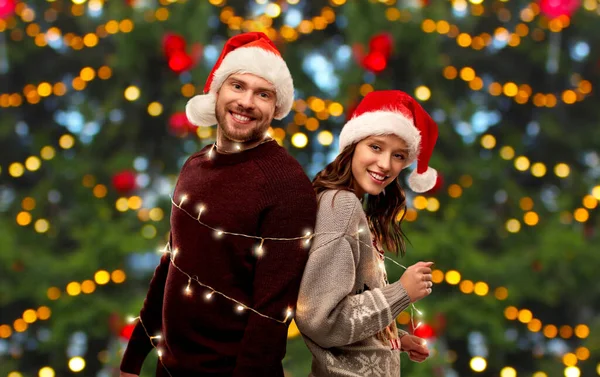 Feliz pareja en suéteres de Navidad y sombreros de santa — Foto de Stock
