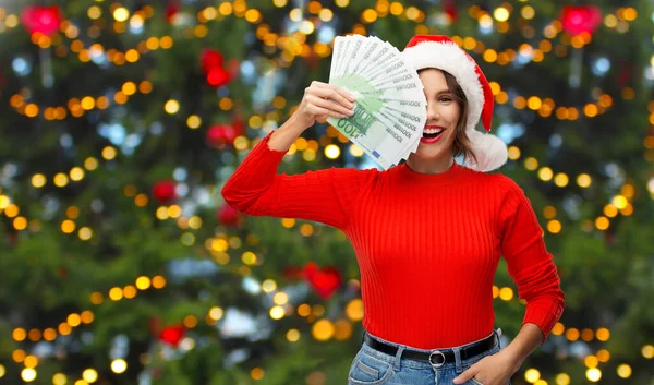 Ευτυχισμένη γυναίκα με καπέλο Σάντα με χρήματα τα Χριστούγεννα — Φωτογραφία Αρχείου