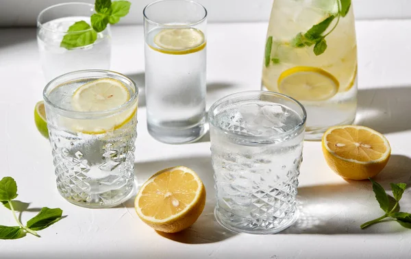 Poharak citromos vízzel és borsmentával az asztalon — Stock Fotó