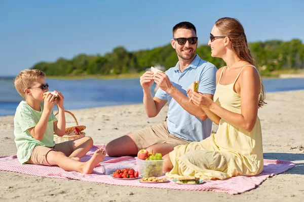 夏のビーチでピクニックをしている幸せな家族 — ストック写真