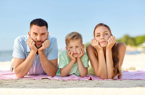 Olycklig familj som ligger på sommarstranden — Stockfoto