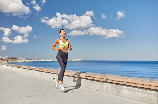 Giovane donna che corre lungo il lungomare — Foto Stock