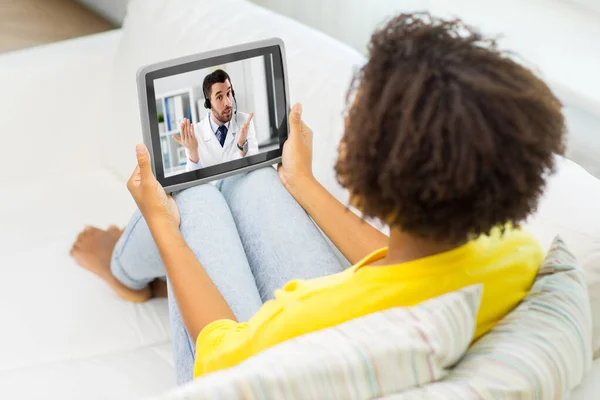 Mujer que recibe videollamada con el médico en la tableta PC —  Fotos de Stock