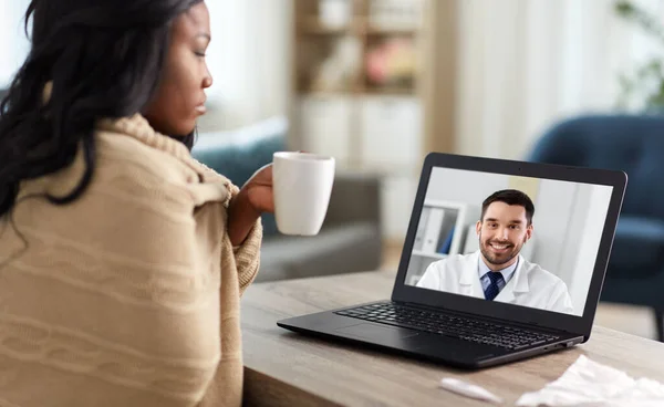 Sick woman having video call with doctor on laptop — Stock Photo, Image