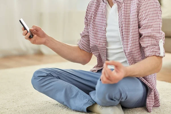 Primer plano del hombre con smartphone meditando en casa —  Fotos de Stock