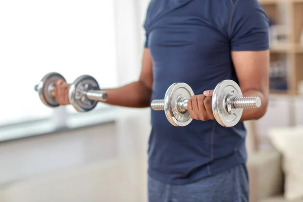 Man exercising with dumbbells at home — Stock Photo, Image