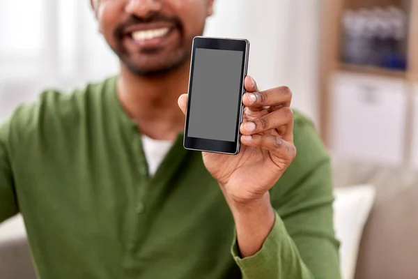 Primo piano di uomo sorridente mostrando smartphone a casa — Foto Stock