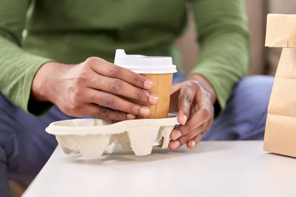 Close up of man with takeaway coffee and food — Stock Photo, Image