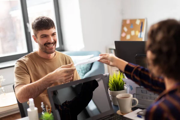 Smiling man taking papers from colleague at office — Stock Photo, Image