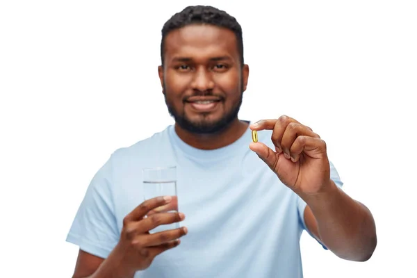 Афроамериканський чоловік з таблеткою і склянкою води — стокове фото