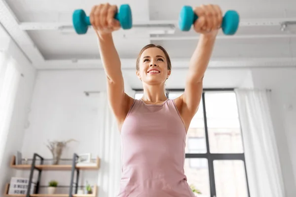 Sourire jeune avec haltères exercice à la maison — Photo