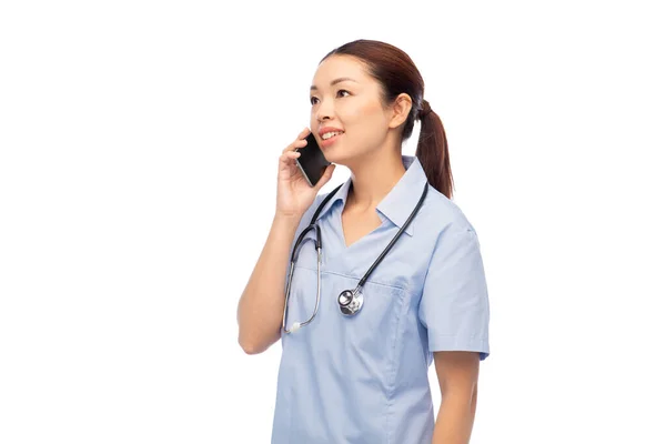 Asiatisk kvinnlig läkare eller sjuksköterska ringer på smartphone — Stockfoto