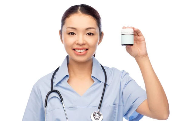 Улыбающаяся азиатская женщина врач или медсестра с медициной — стоковое фото