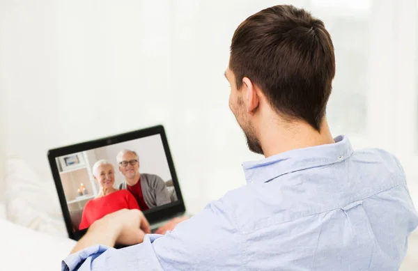 Чоловік з ноутбуком має відеодзвінок зі своєю сім'єю — стокове фото