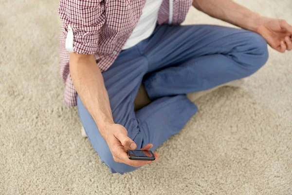 Primer plano del hombre con smartphone meditando en casa — Foto de Stock