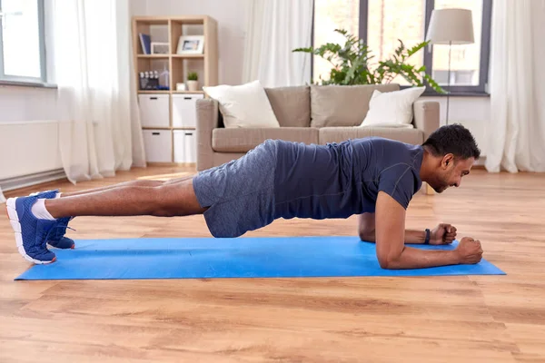 Hombre indio haciendo ejercicio de tablón en casa — Foto de Stock