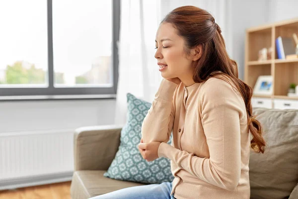 Asiatin leidet zu Hause unter Schmerzen in der Hand — Stockfoto