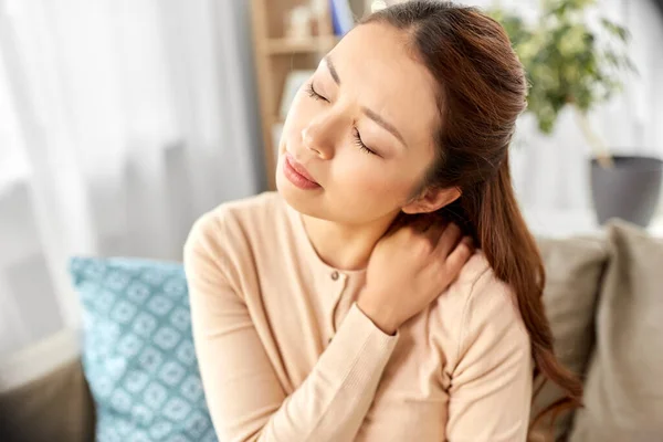 アジア系の女性は家で首に痛みを感じ — ストック写真