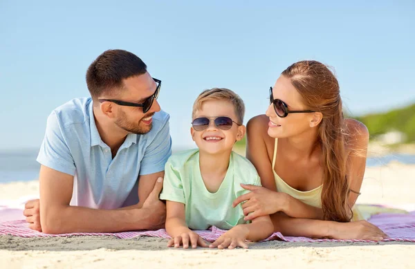 Família feliz deitado na praia de verão — Fotografia de Stock