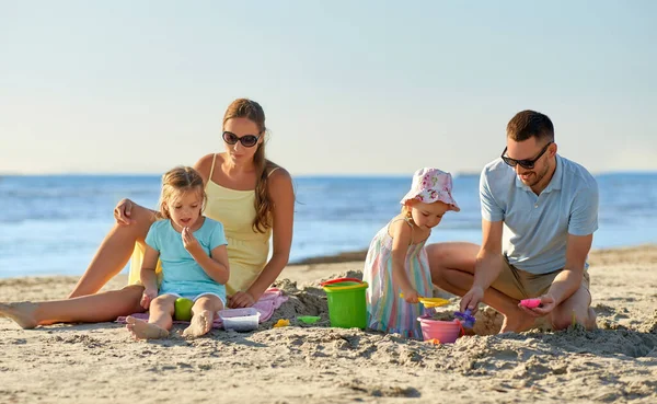 Szczęśliwa rodzina z dziećmi bawiącymi się na letniej plaży — Zdjęcie stockowe