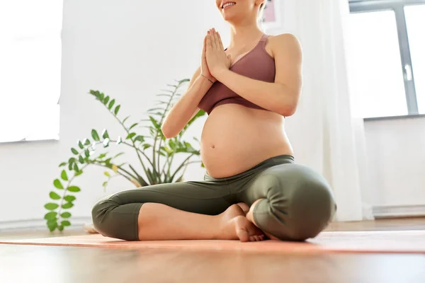 Беременная женщина медитирует дома — стоковое фото