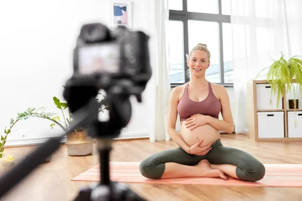 Pregnant woman or yoga blogger with camera at home — Stock Photo, Image