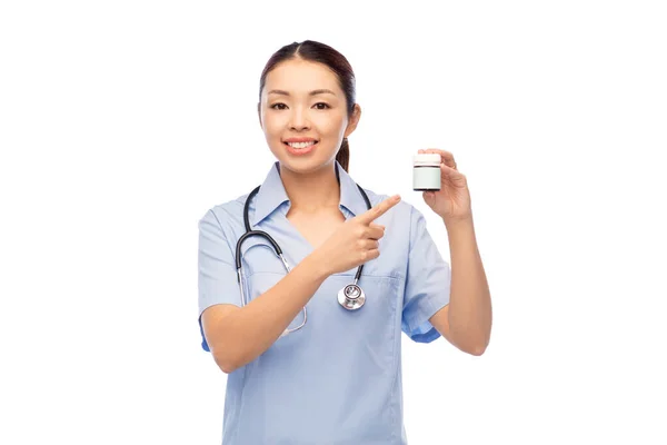 Sorrindo asiático feminino médico ou enfermeira com medicina — Fotografia de Stock