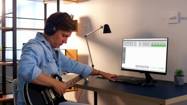 Muž hraje na kytaru a doma nahrává hudbu — Stock video