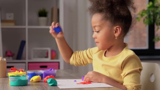 Kleines Mädchen mit Modelliermasse spielt zu Hause — Stockvideo