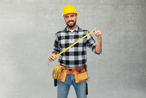 Happy male worker or builder in helmet with ruler — Stock Photo, Image