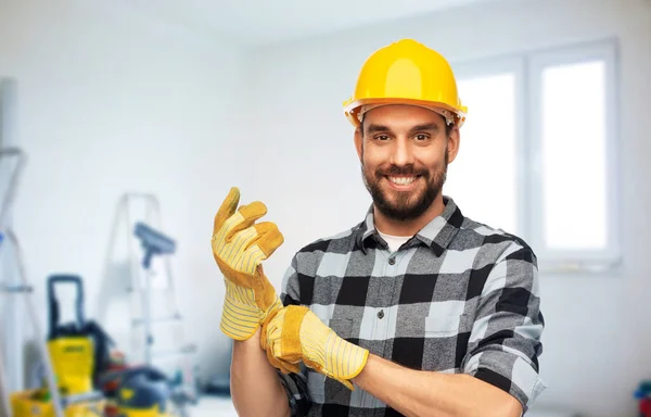 Glücklicher männlicher Arbeiter oder Bauarbeiter mit Helm und Handschuhen — Stockfoto