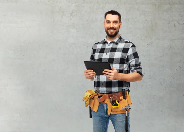 Счастливый строитель с планшетным компьютером и инструментами — стоковое фото