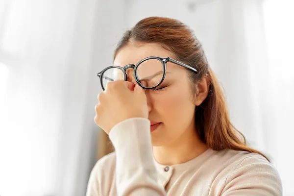 Zmęczony Azji kobieta z okulary tarcie nos most — Zdjęcie stockowe