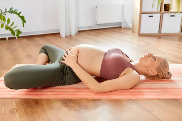 Glad gravid kvinna som gör yoga hemma — Stockfoto