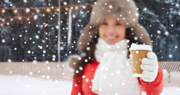 Mulher feliz com xícara de café sobre pista de gelo de inverno — Fotografia de Stock