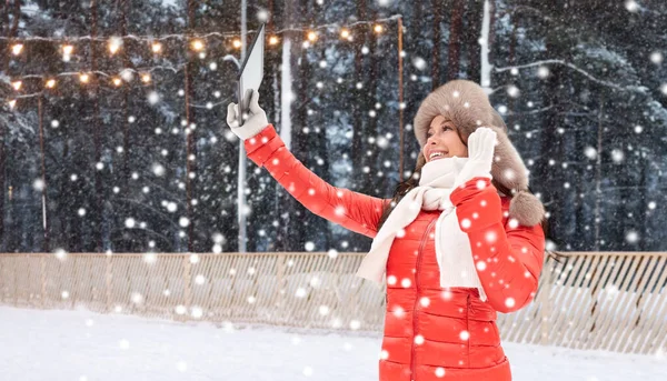 Mujer en sombrero de piel de invierno con tableta pc en pista de hielo —  Fotos de Stock