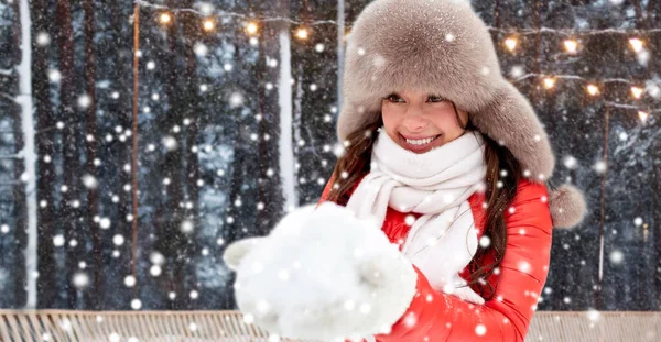 Glad kvinna med snö i vinter hatt på ishall — Stockfoto