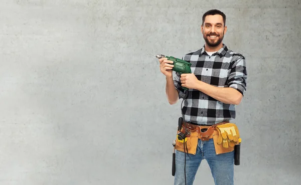 Feliz trabajador masculino o constructor con taladro y herramientas — Foto de Stock