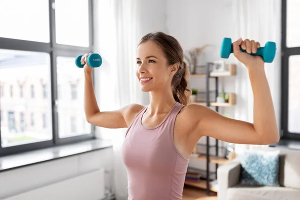 Sourire jeune avec haltères exercice à la maison — Photo