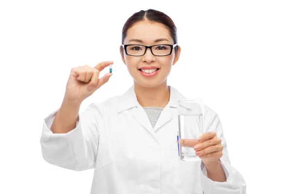 Asiático médico com medicina e copo de água — Fotografia de Stock