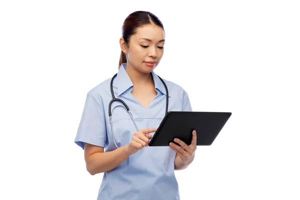 Aziatische vrouwelijke verpleegster met tablet pc en stethoscoop — Stockfoto