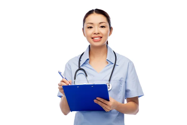 Счастливая улыбающаяся азиатка-врач с планшетом — стоковое фото