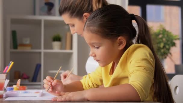 Мать с маленькой дочерью рисует дома — стоковое видео