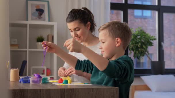 Mãe e filho jogando modelagem argila em casa — Vídeo de Stock