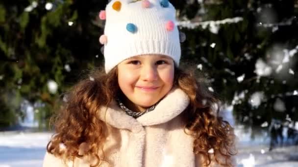 Щаслива маленька дівчинка в зимовому одязі на відкритому повітрі — стокове відео
